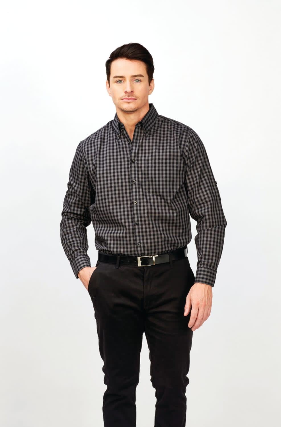 A long sleeve shirt in a black and grey checkered pattern, featuring a logo, worn by a model with dark hair. Barrett - Mens Long Sleeve Shirt - Image 1