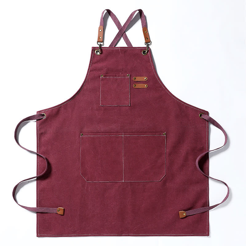 A maroon canvas apron featuring straps, pockets, and a logo. Canvas Household Apron - Image 1
