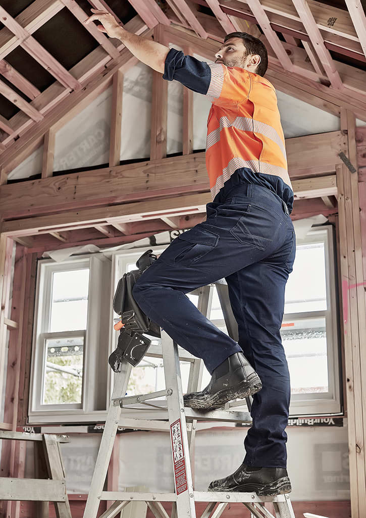 Men's cargo pant in navy, worn by a man on a ladder, working in a partially constructed building. The pants have pockets and a logo. Mens Summer Cargo Pant (Stout) - Image 1