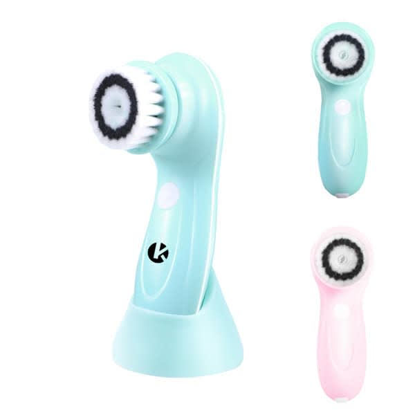 An electric facial cleansing brush in mint and pink colours, featuring a stand for storage and interchangeable brush heads. Electric Facial Cleansing Brush - Image 1
