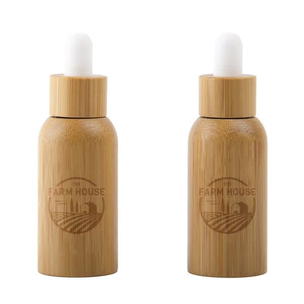 A 20ml glass dropper bottle with a bamboo shell, featuring natural wood tones and a white dropper top. 20ml Glass Dropper Bottle With Bamboo Shell - Image 1