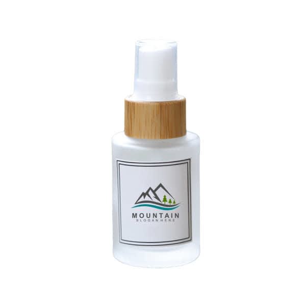 A frosted glass spray bottle with a white and bamboo cap, featuring a logo. 1 oz. Frosted Glass Spray Bottle - Image 1