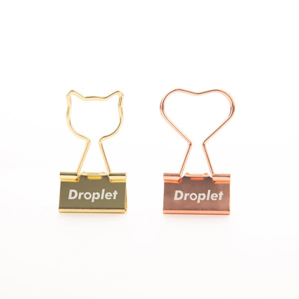 A gold and rose gold metal binder clip, featuring a cat and heart design, with a logo on the front. Customized Cute Gold Plated Metal Binder Clip - Image 1