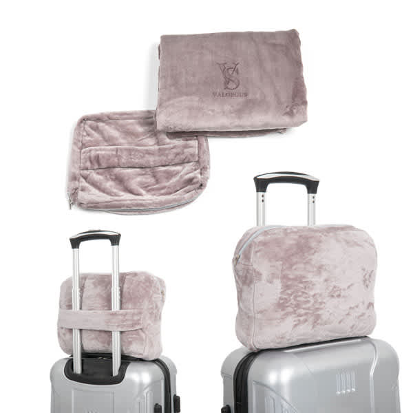 A flannel travel blanket in a soft mauve colour, accompanied by a matching zipper bag, displayed on luggage. Flannel Travel Blanket With Zipper Bag - Image 1