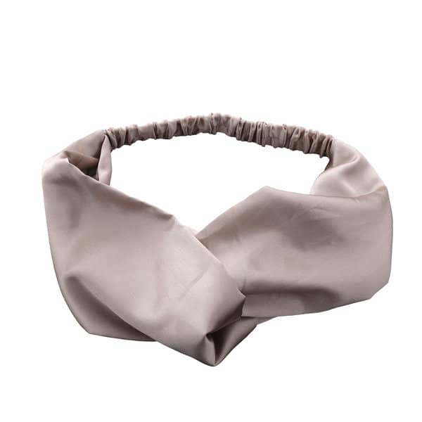 A crisscross headband in a soft beige hue, featuring a stretchy band for a comfortable fit. Silk Satin Crisscross Headband - Image 1
