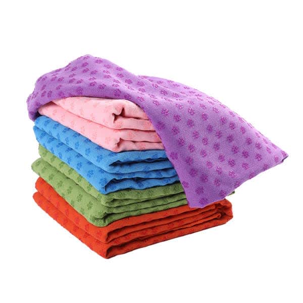 A stack of microfiber yoga towels in purple, pink, blue, green, and red, featuring grip dots and a logo. Microfiber Yoga Towel With Grip Dot - Image 1