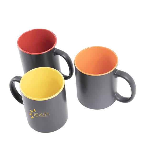 Three ceramic coffee mugs with black exteriors and vibrant coloured interiors in red, yellow, and orange. Each has a handle. Custom 11 oz. Two Tone Ceramic Coffee Mug - Image 1