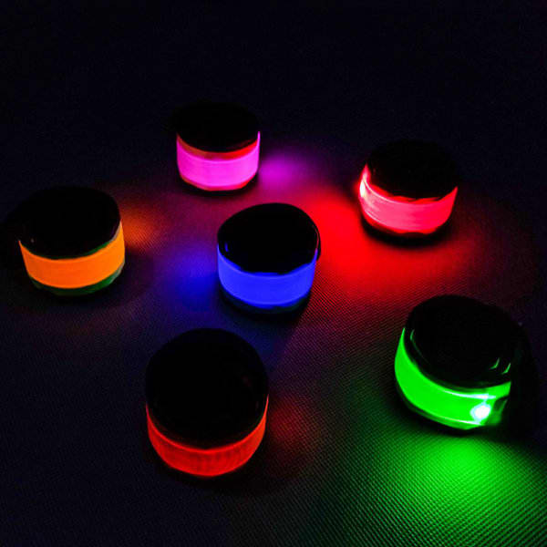 A set of six LED luminous slap armbands in orange, pink, blue, green, and purple, featuring a black top and glowing brightly. Custom LED Luminous Slap Armband - Image 1