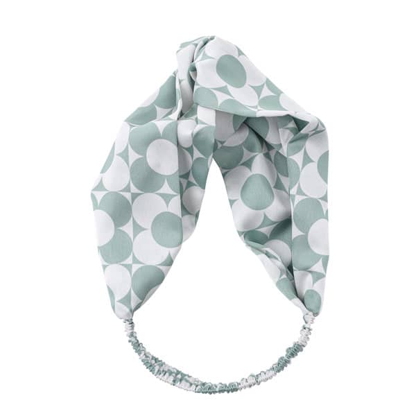 A mint green satin cross headband featuring a geometric pattern in white. It has an elasticated band for comfort. Custom Satin Cross Headband - Image 1