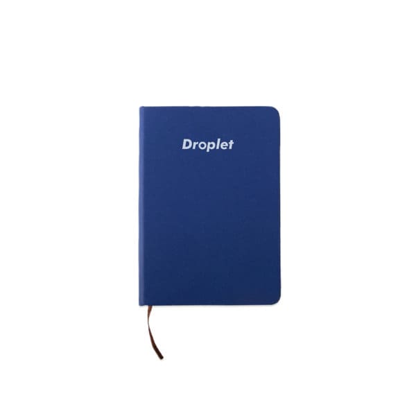 A6 hardcover pocket journal in blue with a logo on the front and a brown ribbon bookmark. A6 Hardcover Pocket Journal - Image 1