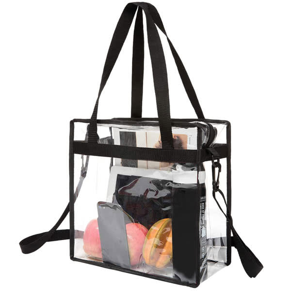 A clear tote bag with a black shoulder strap, containing a phone, water bottle, and two apples. Clear Stadium Approved Tote Bag With Shoulder Strap - Image 1