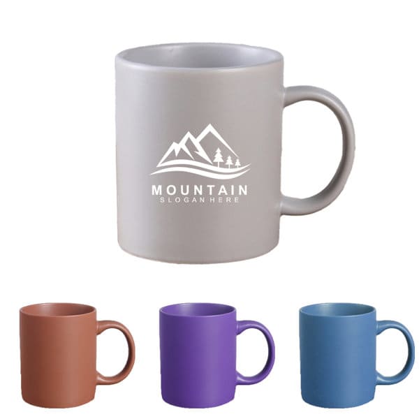 A collection of ceramic coffee mugs in grey, brown, purple, and blue, featuring a logo on the grey mug. Custom Ceramic Coffee Mug - Image 1