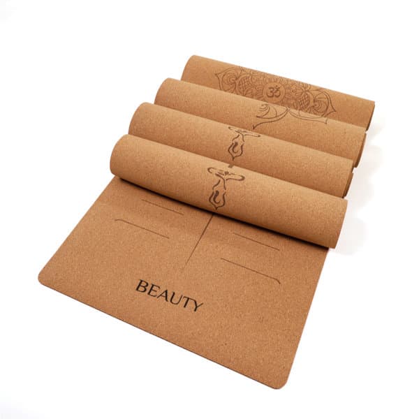 A cork rubber yoga mat in a natural tan colour with engraved designs and the word "BEAUTY" on it. It has a logo. Cork Rubber Yoga Mat - Image 1