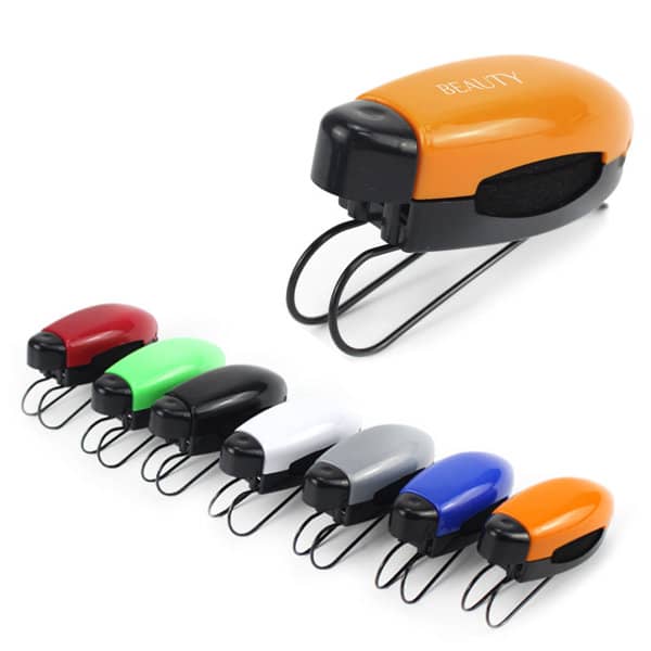 A set of staplers in various colours: red, green, white, black, grey, and orange, with one orange stapler in the foreground. Car Sunglass Visor clip - Image 1