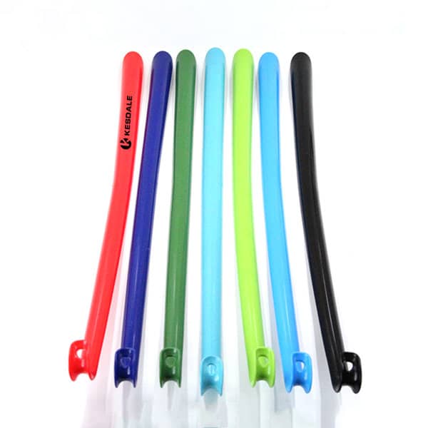 A set of eight plastic long handle shoe horns in various colours: red, green, blue, black, and clear. Each has a logo. Plastic Long Handle Shoe Horn - Image 1