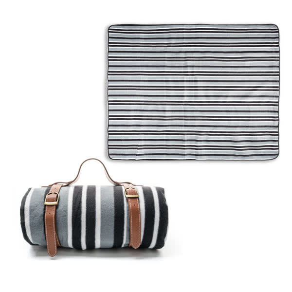 A fleece picnic blanket in black and white stripes, rolled up with a leather strap for easy carrying. Fleece Picnic Blanket With Leather Strap - Image 1