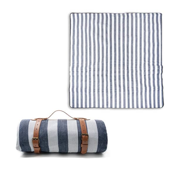 A striped picnic blanket in shades of navy and white, rolled up with a brown leather carry handle, featuring a logo. Picnic Blanket With Leather Carry Handle - Image 1
