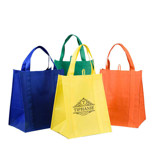 A set of four RPET non-woven shopping tote bags in blue, green, yellow, and orange, featuring a logo on one bag. RPET Non-woven Shopping Tote Bag - Image 1