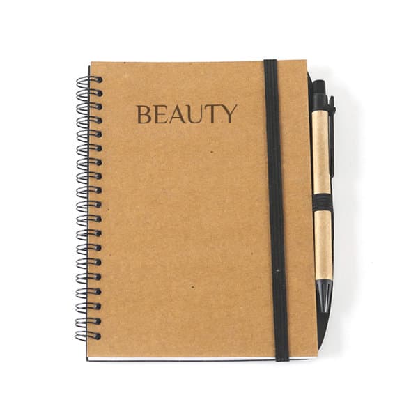 A brown coil notebook with a black elastic band and a pen attached, featuring the word "BEAUTY" on the cover. Coil Notebook With Insert Pen - Image 1