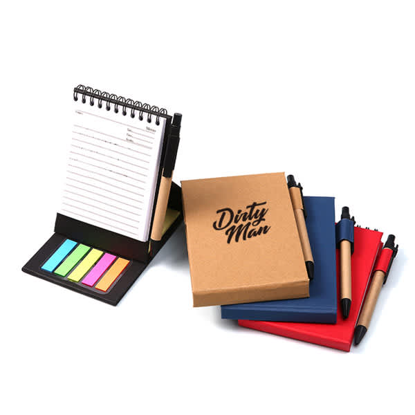 A spiral notepad with sticky notes in pastel colours, accompanied by a red, blue, and brown notebook with pens. Craft Spiral Standing Notepad With Sticky Notes - Image 1