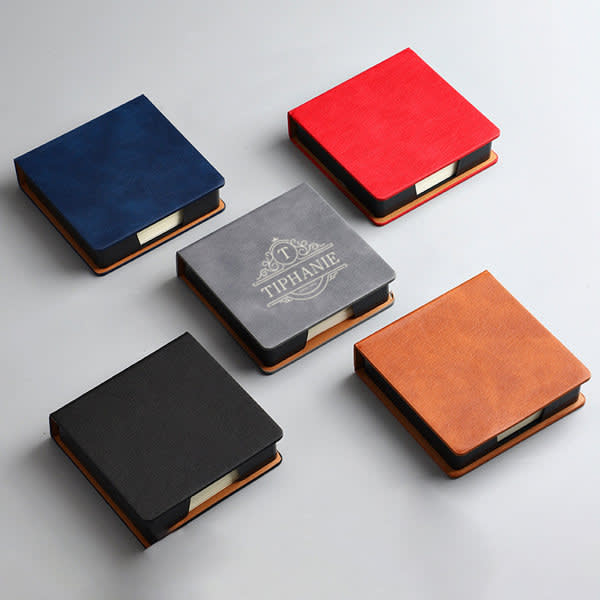 A PU leather note storage box in navy, grey, red, black, and brown, featuring paper inside and a logo on one box. PU Leather Note Storage Box With Paper - Image 1