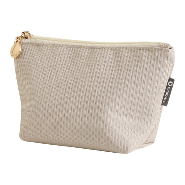 A beige toiletry bag with a textured design and a gold zipper, featuring a small logo on the side. Carry-on Makeup Bag - Image 1