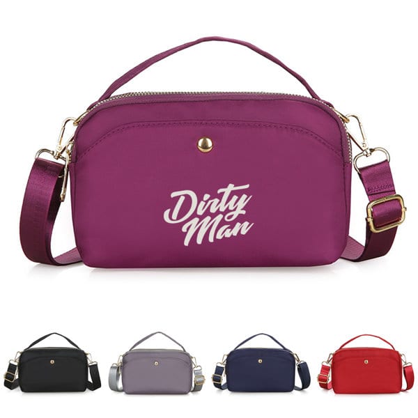 A nylon crossbody bag in purple with a logo, featuring a detachable strap and zippered closure. Also available in black, grey, navy, and red. Nylon Crossbody Bag - Image 1
