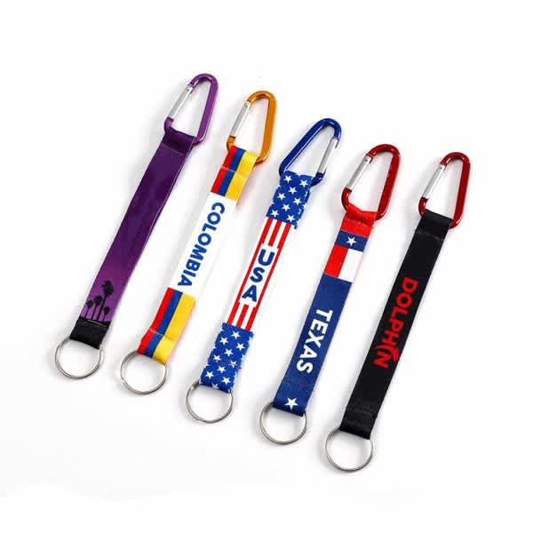 A collection of five carabiner keychains with colourful straps featuring various designs and logos. Carabiner keychain With Strap - Image 1