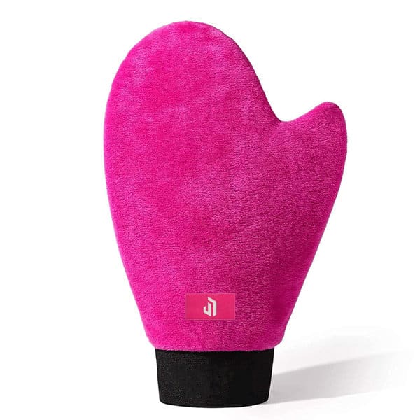 A pink self tanning mousse mitt with a soft, plush texture and a black base, featuring a branding logo. Self Tanning Mousse Mitt - Image 1