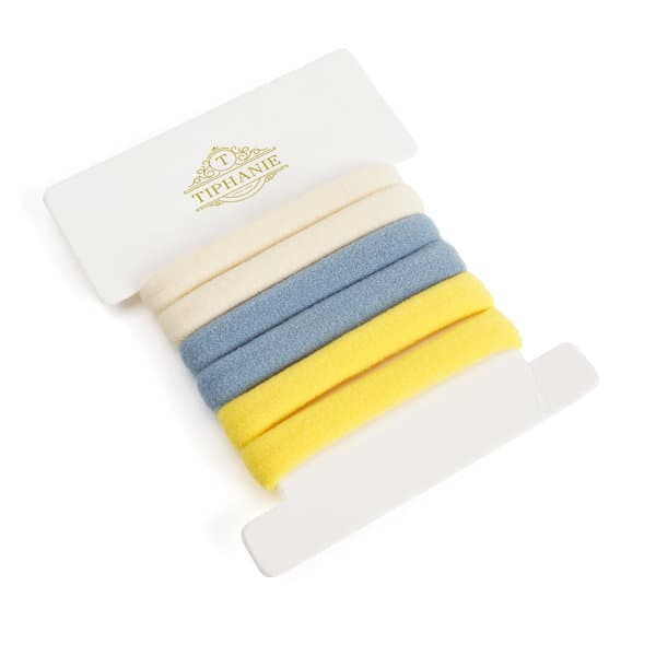A set of hair ties in blue, yellow, cream, and a textured finish, presented on a white backing with a logo. Hair Ties Set - Image 1