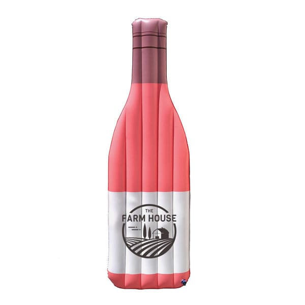 An inflatable champagne bottle pool float in shades of pink and white, featuring a logo on the front. Inflatable Champagne Bottle Pool Float - Image 1