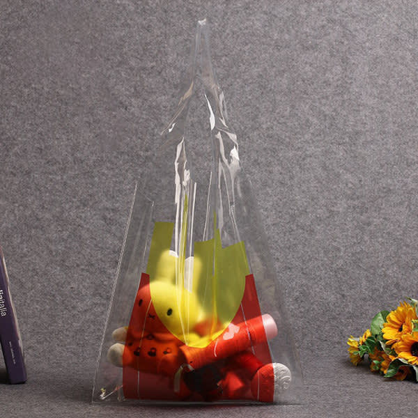A clear PVC tote bag containing colourful plush toys, featuring a logo on the exterior. Stylish Clear PVC Shopping Tote Bag - Image 1