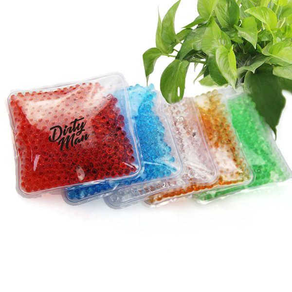 Five square gel bead ice packs in various colours, including red, blue, green, orange, and clear, arranged with foliage. Square Cold Gel Beads Ice Pack - Image 1
