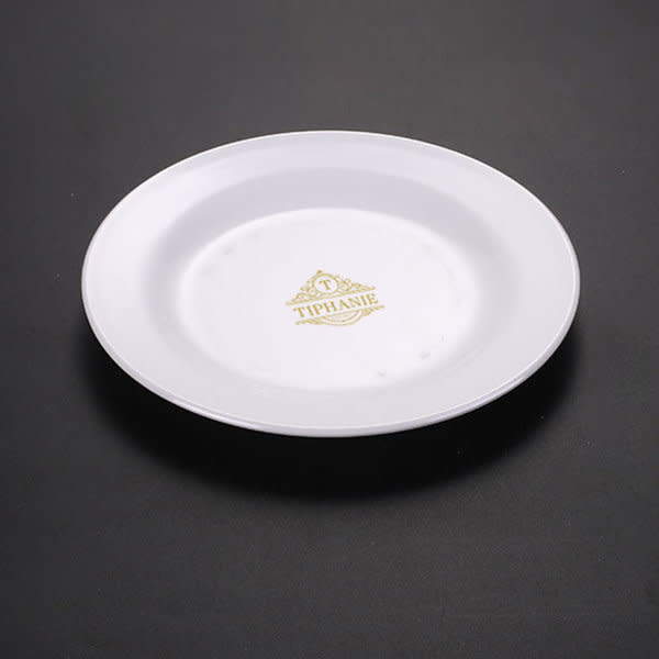 A white 8-inch round luncheon plate with a decorative logo in gold. 8 Inch Round Luncheon Plate - Image 1