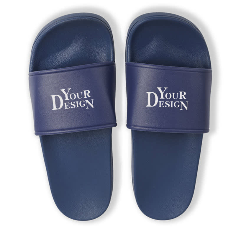 A pair of navy blue PVC non-slip slippers featuring a branded strap. Promotional PVC Non Slip Slippers - Image 1