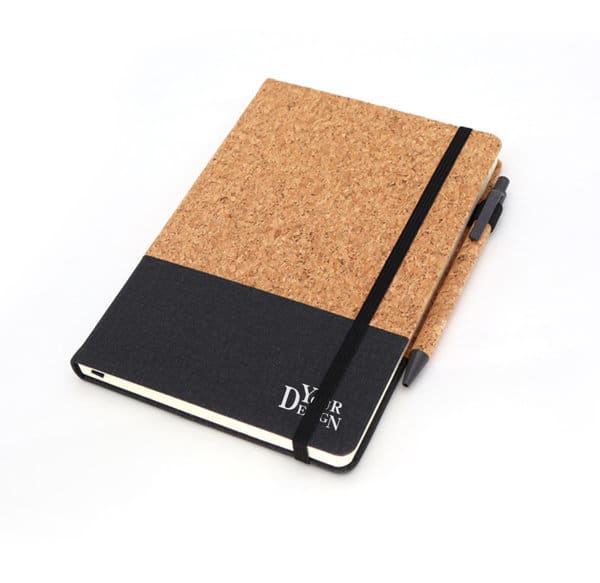 A5 cork notebook in tan with a black lower section, accompanied by a matching pen. Features an elastic closure and branding. A5 Cork PU Notebook With Pen - Image 1