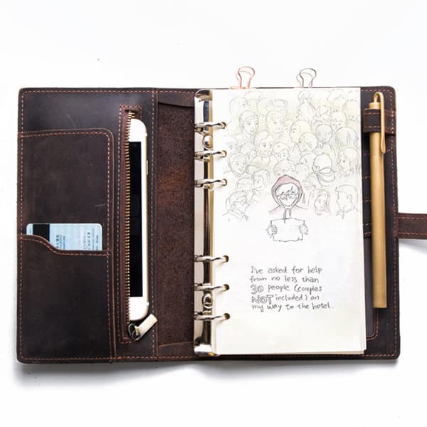 A brown multifunctional vintage spiral travel notebook binder with a pen, pockets, and blank pages inside. Multifunctional Vintage Spiral Travel Notebook Binder - Image 1