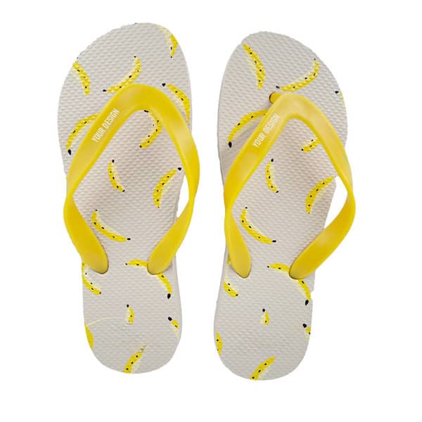 Rubber flip flops with yellow PVC straps and a banana print on a white background. Rubber Flip Flops With PVC Straps - Image 1