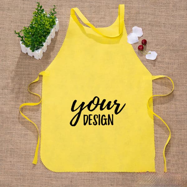 A yellow waist apron with ties, featuring a space for custom design and a logo. Green plant and decorative elements nearby. Custom Restaurant Waist Apron - Image 1
