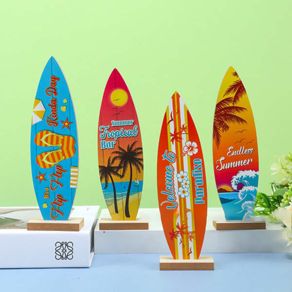 A collection of four colourful surfboard ornaments featuring tropical designs, displayed on wooden bases against a green background. Surfboard Desktop Ornament - Image 1