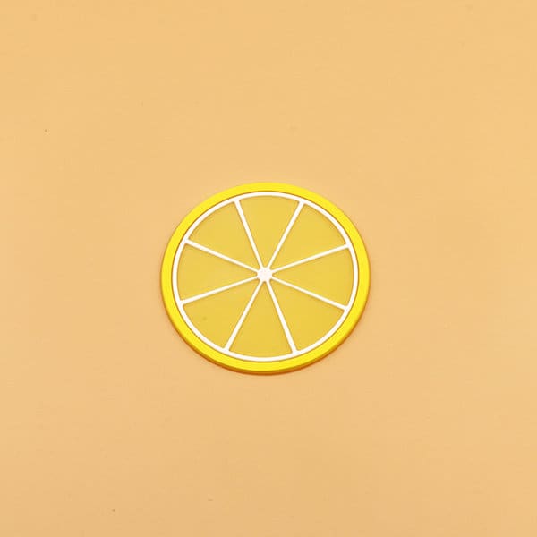 A yellow silicone coaster shaped like a lemon slice, featuring white detailing and a circular design. Non-Slip Insulation Silicone Coaster - Image 1