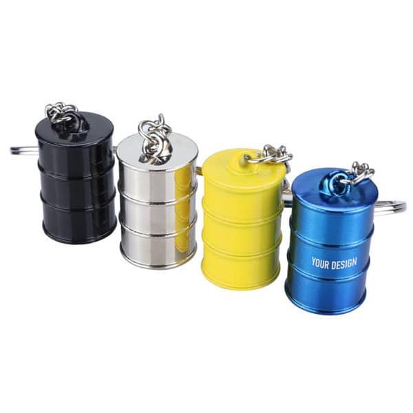 A set of four key chains shaped like mini oil buckets in black, silver, yellow, and blue, each with a keyring attachment. Custom Oil Bucket Key Chain - Image 1