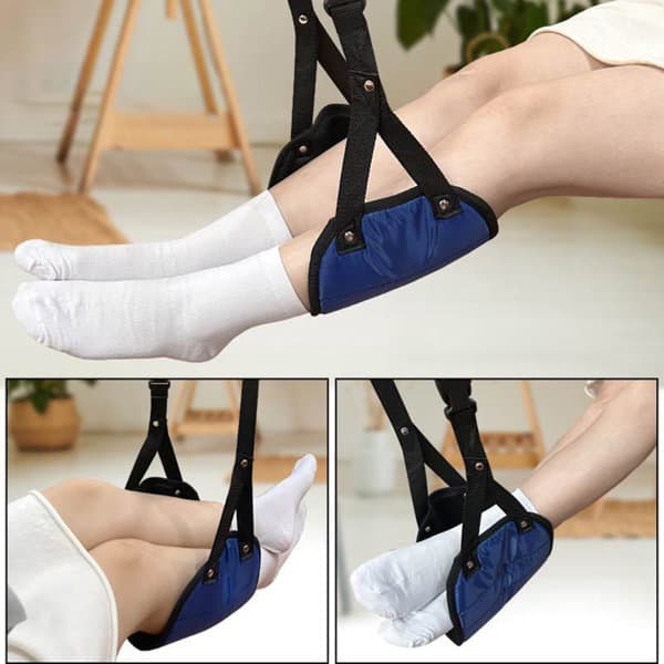 A portable footrest in navy blue with adjustable straps, designed for use during travel, featuring padded support. Portable Carry On Airplane Footrest - Image 1