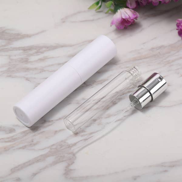 A portable twist spray perfume bottle, featuring a clear glass vial and a white cap with a silver spray nozzle. Portable Twist Spray Perfume Bottle - Image 1