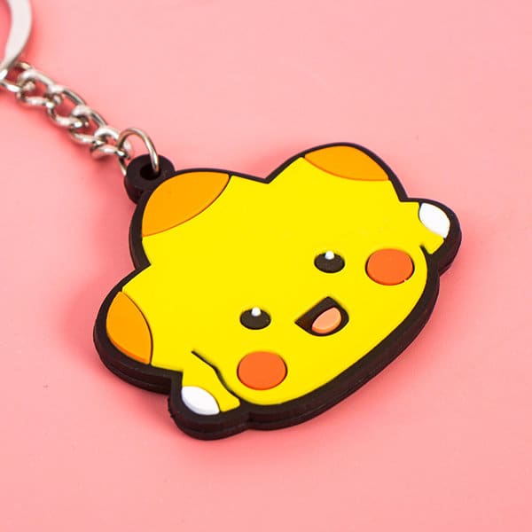 A yellow rubber keyring featuring a cute character with a smiling face and orange accents, attached to a metal chain. Personalized PVC Rubber Keyring - Image 1