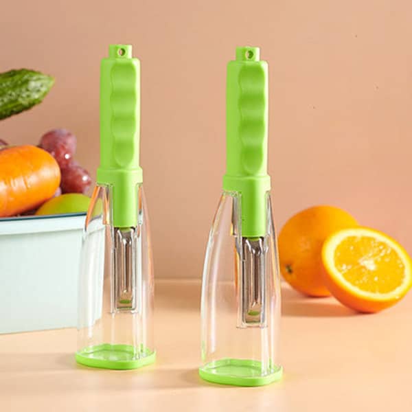 A pair of green peelers with transparent storage boxes, placed against a light background with fruits and vegetables. Peeler With Storage Box - Image 1
