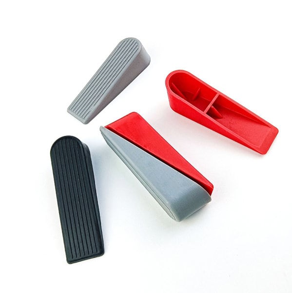 A set of four silicone door stops in red, grey, and black, featuring different designs and grooves. Promotional Silicone Door Stop - Image 1