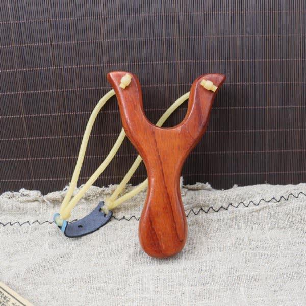 A custom wooden slingshot in a rich brown colour with yellow rubber bands and a small metal component. Custom Wood Slingshot - Image 1