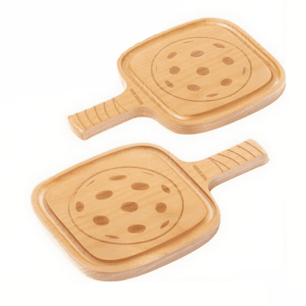 Two wooden pickleball coasters with round cutouts, featuring a light natural finish and smooth handles. Custom Pickleball Coaster - Image 1