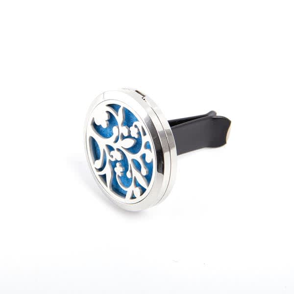 A circular car essential oil vent clip featuring intricate silver detailing and a blue background. It has a black clip attachment. Car Essential Oil Vent Clip - Image 1